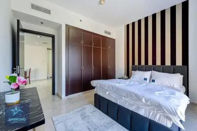 a bedroom with a large bed and a table at Peaceful 1BR JVC Near Circle Mall Pool Gym in Dubai