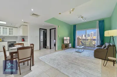 a living room with a kitchen and a dining room at Peaceful 1BR JVC Near Circle Mall Pool Gym in Dubai