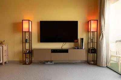 a living room with a television and two lamps at Meydan Boutique Loft Near Downtown in Dubai