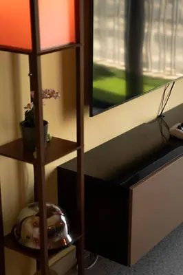 a lamp sitting next to a wall with a television at Meydan Boutique Loft Near Downtown in Dubai
