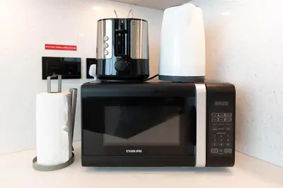 a microwave with a coffee pot on top of it at Luxury 3BR Skyline Apartment - Sobha The Crest Dubai in Dubai