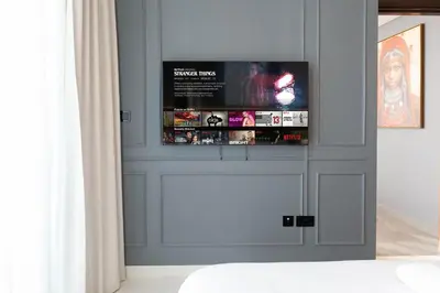 a living room with a tv on a wall at Luxury 3BR Skyline Apartment - Sobha The Crest Dubai in Dubai