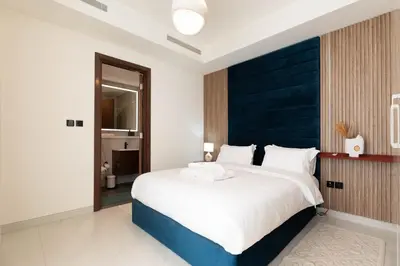 a bedroom with a large bed with a blue headboard at Luxury 3BR Skyline Apartment - Sobha The Crest Dubai in Dubai