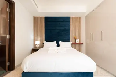 a bedroom with a large white bed with a blue headboard at Luxury 3BR Skyline Apartment - Sobha The Crest Dubai in Dubai