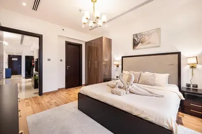 a bedroom with a large bed and a chandelier at Enjoy 8-Day NYE Spectacles with Burj Khalifa View in Dubai