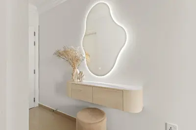 a mirror on the wall of a room with a stool at VayK - Vibrant and Great 1BR in the Marina in Dubai
