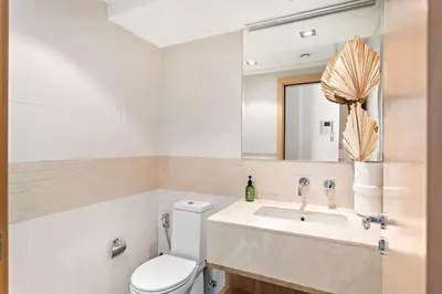 a bathroom with a toilet and a sink and a mirror at VayK - Exquisite 2BR with Panoramic Marina View in Dubai
