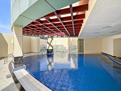 a large swimming pool with blue water in a building at VayK - Welcoming and Warm 2BR in JLT in Dubai