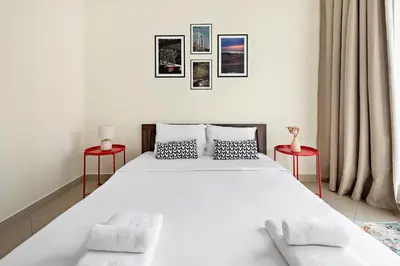 a bedroom with a large white bed with two red tables at VayK - Welcoming and Warm 2BR in JLT in Dubai