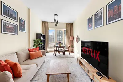 a living room with a couch and a tv at VayK - Welcoming and Warm 2BR in JLT in Dubai