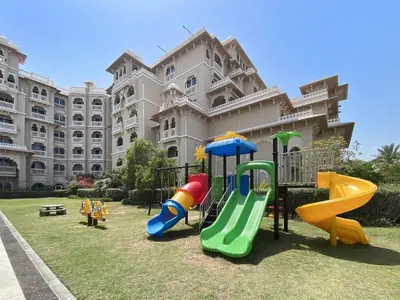 a playground in front of a large building at VayK - Stylish 1BR in Palm Jumeirah with Secluded Beach Access in Dubai