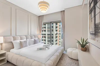 a bedroom with a large white bed and a large window at Elevated 2 Bedroom with Khalifa view in Peninsula in Dubai