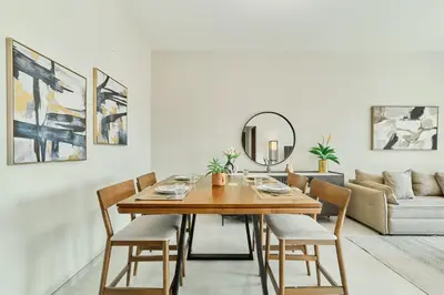 a dining room with a wooden table and chairs at Chic 1BR Getaway in Tulip Oasis 9 Majan in Dubai