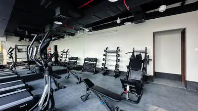 a gym with several treadmills and exercise machines at Chic 1BR Getaway in Tulip Oasis 9 Majan in Dubai