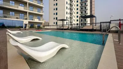 a swimming pool with white sculptures in a building at Chic 1BR Getaway in Tulip Oasis 9 Majan in Dubai