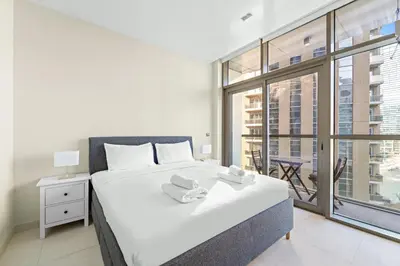 a bedroom with a bed and a large window at VayK - Chic Marina-Front 1BR in a Luxurious Location in Dubai