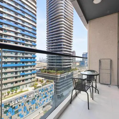 a balcony with a table and chairs and a large building at Heart of Downtown Luxury 1BHK Dunya in Dubai