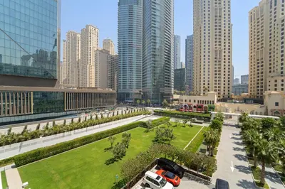 a park in the middle of a city with tall buildings at VayK - Feel the Festive Vibe in Cozy 1BR with Beach Access in Dubai