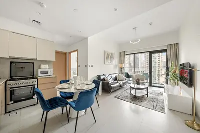 a kitchen and living room with a table and chairs at VayK - Iconic 1BR in Downtown in Dubai