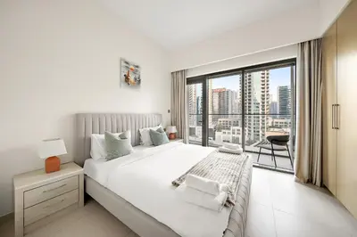 a bedroom with a large bed and a large window at VayK - Iconic 1BR in Downtown in Dubai