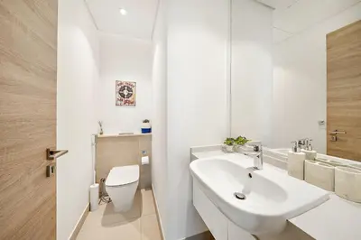 a white bathroom with a sink and a toilet at VayK - Bright and Stylish 1BR in Marina in Dubai