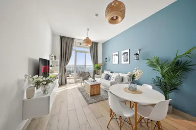 a living room with a table and a couch at VayK - Bright and Stylish 1BR in Marina in Dubai