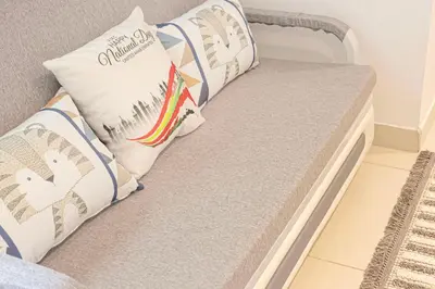 a couch with two pillows on top of it at Stylish Stay at DAMAC Maison Cour Jardin Canalview in Dubai