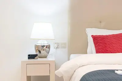 a bedroom with a bed and a table with a lamp at Stylish Stay at DAMAC Maison Cour Jardin Canalview in Dubai
