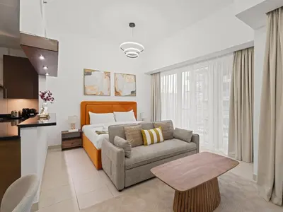 a bedroom with a bed and a couch and a table at Dreamy Haven Studio in West Wharf in Dubai