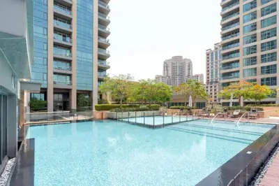 a large swimming pool in a building with tall buildings at Dreamy Haven Studio in West Wharf in Dubai