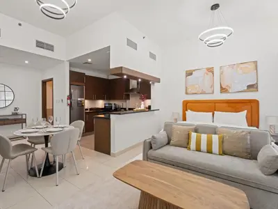 a living room and kitchen with a couch and a table at Dreamy Haven Studio in West Wharf in Dubai