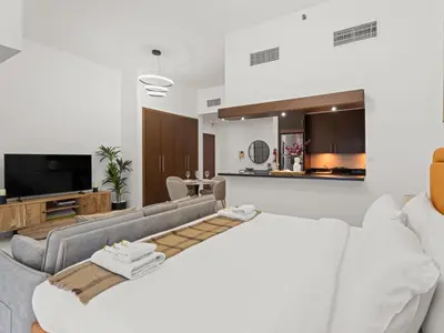 a living room with a couch and a tv at Dreamy Haven Studio in West Wharf in Dubai
