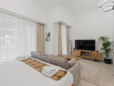a living room with a couch and a tv at Dreamy Haven Studio in West Wharf in Dubai