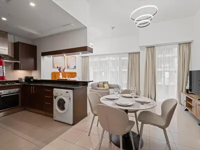 a kitchen and living room with a table and chairs at Dreamy Haven Studio in West Wharf in Dubai