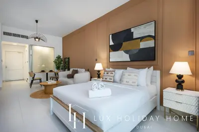 a bedroom with a large bed and a living room at LUX The Palm Sea View Studio in Dubai