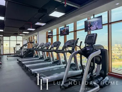 a row of treadmills in a gym with windows at LUX The Palm Sea View Studio in Dubai