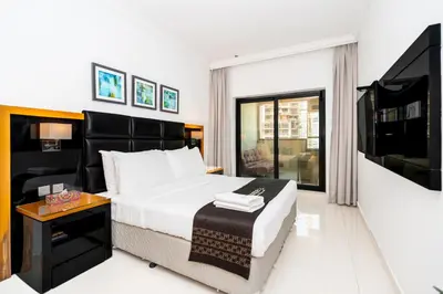 a bedroom with a bed and a flat screen tv at Escape24 Cozy Studio at Capital Bay near Burj Khalifa in Dubai
