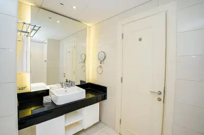a white bathroom with a sink and a mirror at Escape24 Cozy Studio at Capital Bay near Burj Khalifa in Dubai