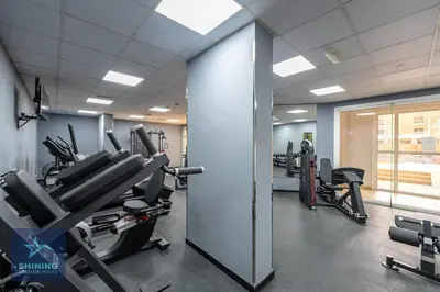 a gym with treadmills and machines in a room at Luxury Spacious 1BR JVC 2Bath Pool Gym in Dubai