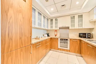 a large kitchen with wooden cabinets and appliances at Golden Homes Aqua Bay 1BR-BLVD CENTRAL Downtown Dubai mall in Dubai