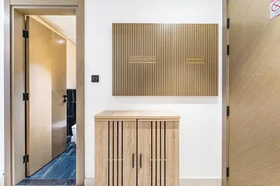 a bathroom with a mirror and a wooden cabinet at HAVN- 1 Bedroom in Binghatti, Al Jaddaf in Dubai