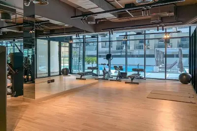 an office with a gym with a pool in the background at HAVN- 1 Bedroom in Binghatti, Al Jaddaf in Dubai