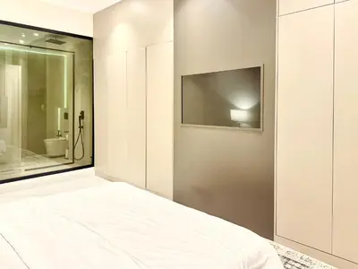 a bedroom with a bed and a tv on a wall at Luxury Studio Apartment Near Jumeirah Beach in Dubai