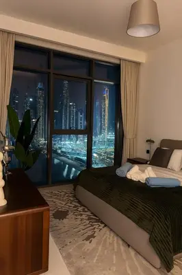 a bedroom with a large window with a city skyline at Marina Vista 2BR High Floor Sea View Emaar Beachfront in Dubai