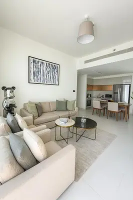 a living room with a couch and a table at Marina Vista 2BR High Floor Sea View Emaar Beachfront in Dubai