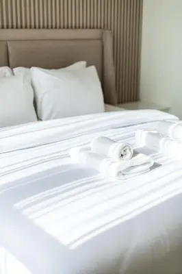 a white bed with white sheets and towels on it at Luxury 5 bed Villa close to Pool, Gym and Play Areas in Dubai