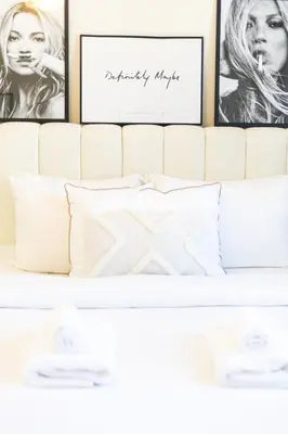 a bedroom with three pictures above a white bed at Luxury 5 bed Villa close to Pool, Gym and Play Areas in Dubai