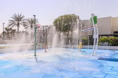 a fountain in a swimming pool with water shooting at Luxury 5 bed Villa close to Pool, Gym and Play Areas in Dubai
