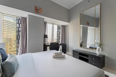 a bedroom with a large white bed and a mirror at GuestReady - 2BR l Marina View + Infinity Pool in Dubai