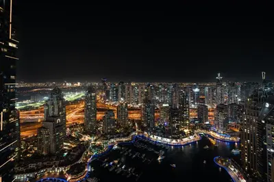 a view of a city at night with lights at GuestReady - 2BR l Marina View + Infinity Pool in Dubai